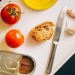 Tomatoes, bread, and sardines arranged for Catalán toast preparation.